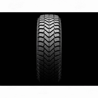 Gros plan sur un pneu de voiture montrant une bande de roulement en bon état et des marqueurs d'usure clairement visibles, avec une main tenant un profondimètre pour vérifier la profondeur de la bande de roulement. L'arrière-plan est légèrement flou, se concentrant sur le pneu.