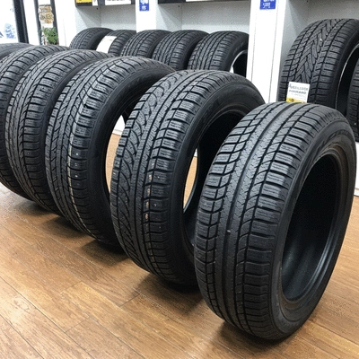 Assortment of different types of tires (winter, summer, all-season) displayed in a neat and organized manner, highlighting their unique treads and features, no text, no words, no typography, no labels, clean image